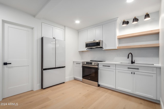 kitchen featuring appliances with stainless steel finishes, decorative backsplash, white cabinetry, light wood-type flooring, and sink