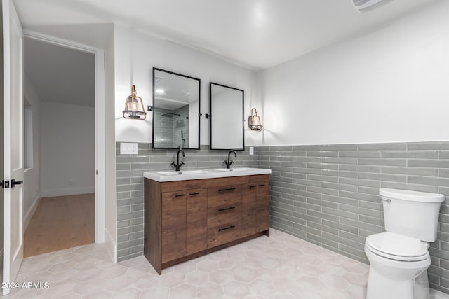 bathroom featuring tile walls, vanity, toilet, and tile patterned floors