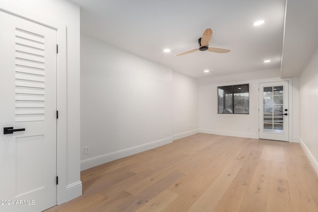 empty room with ceiling fan and light hardwood / wood-style flooring