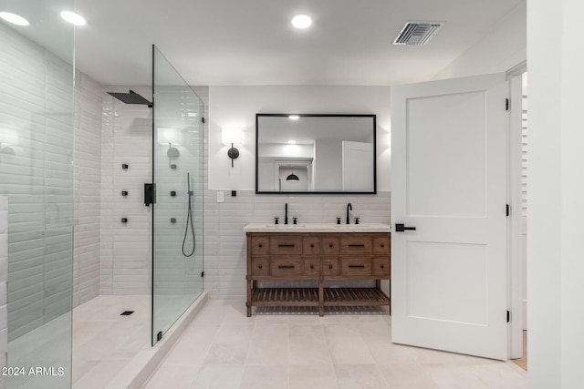 bathroom with tile walls, backsplash, vanity, walk in shower, and tile patterned floors