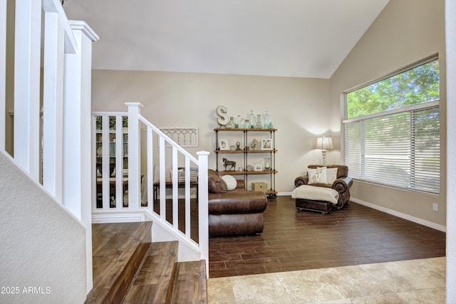 sitting room with baseboards, stairs, wood finished floors, and vaulted ceiling
