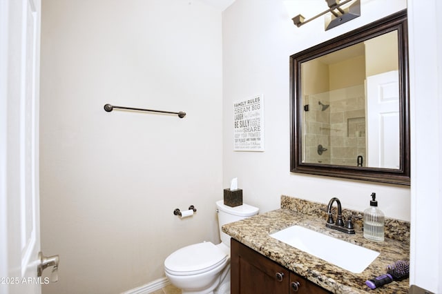 bathroom with vanity, baseboards, a shower, and toilet