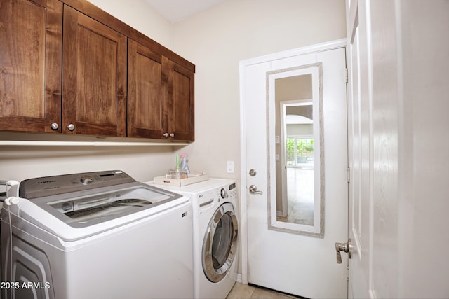 washroom with cabinet space and washer and clothes dryer
