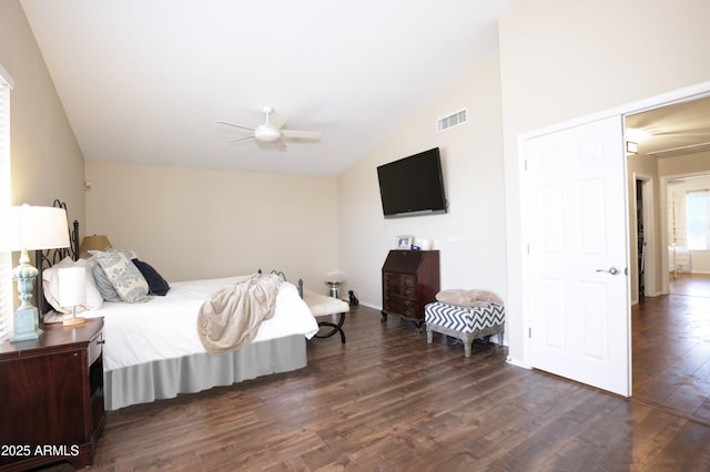 bedroom with visible vents, dark wood-type flooring, vaulted ceiling, and ceiling fan