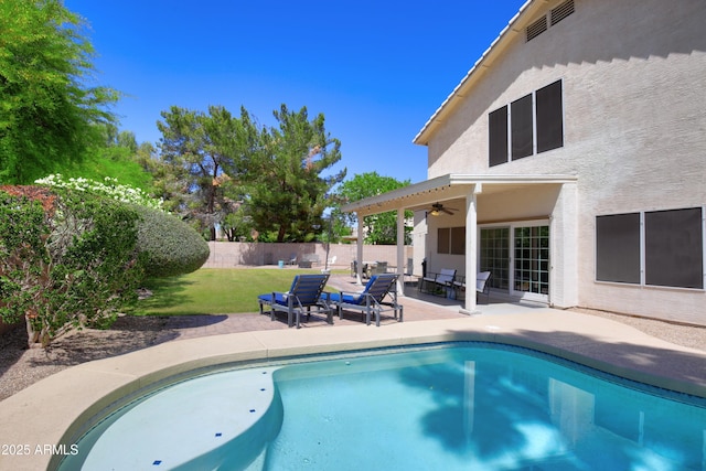 view of pool featuring a fenced backyard, a fenced in pool, a patio area, a lawn, and a ceiling fan