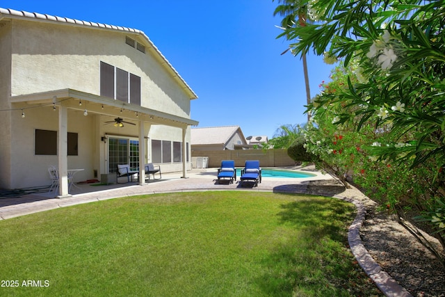 view of yard featuring a fenced backyard, a fenced in pool, a patio, and ceiling fan