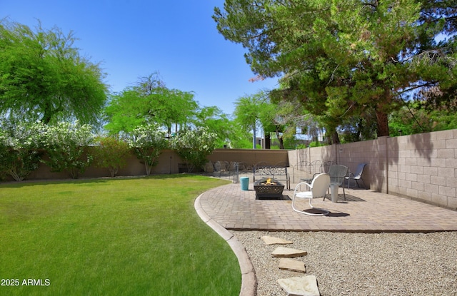view of yard featuring a fenced backyard, a patio, and an outdoor fire pit