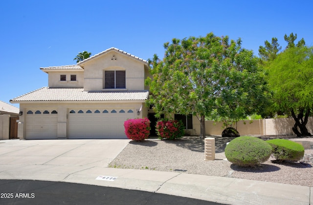view of front of property with fence, an attached garage, a tile roof, stucco siding, and driveway