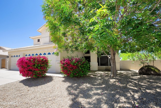 view of front of house featuring a garage, a tile roof, and stucco siding