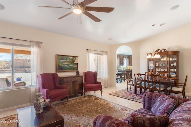 living area featuring a wealth of natural light, visible vents, arched walkways, and light tile patterned floors