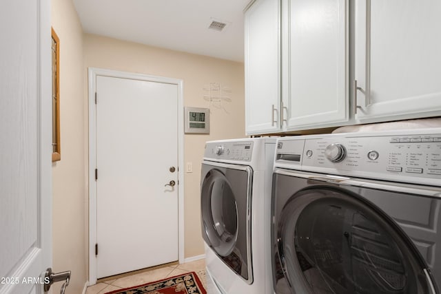 clothes washing area featuring light tile patterned floors, visible vents, cabinet space, and separate washer and dryer