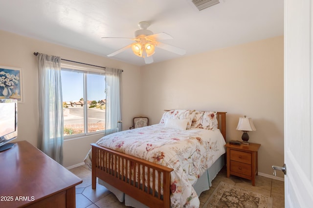 bedroom featuring light tile patterned floors, visible vents, ceiling fan, and baseboards