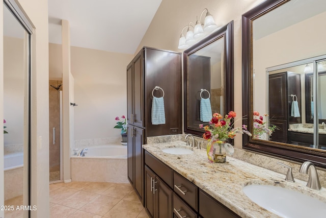 full bath featuring tile patterned floors, a bath, double vanity, and a sink