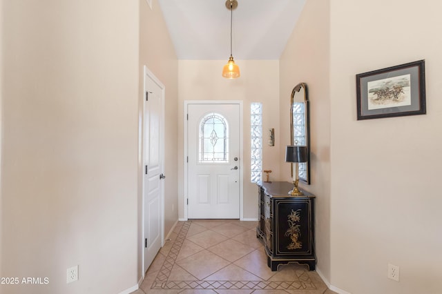 foyer entrance featuring light tile patterned flooring and baseboards