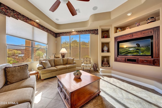 living room featuring built in features, ceiling fan, and light tile patterned flooring