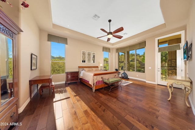 bedroom featuring a raised ceiling, ceiling fan, access to exterior, and dark wood-type flooring