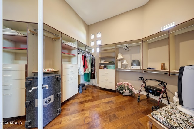 walk in closet with hardwood / wood-style floors and a high ceiling