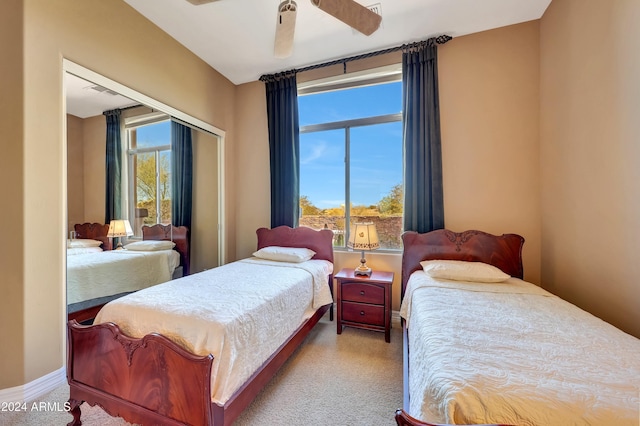 carpeted bedroom featuring multiple windows and ceiling fan