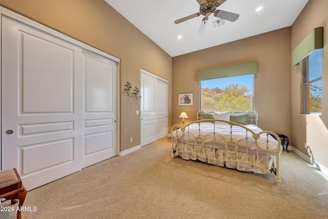 bedroom featuring ceiling fan, carpet, and two closets