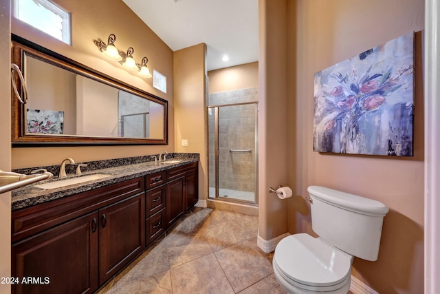 bathroom featuring tile patterned flooring, a shower with door, vanity, and toilet