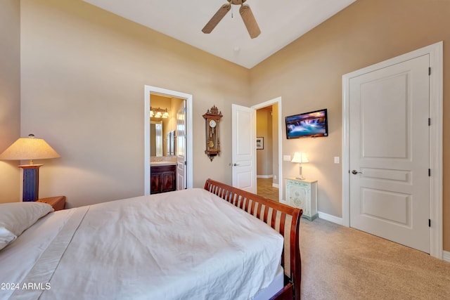 carpeted bedroom with ensuite bathroom and ceiling fan