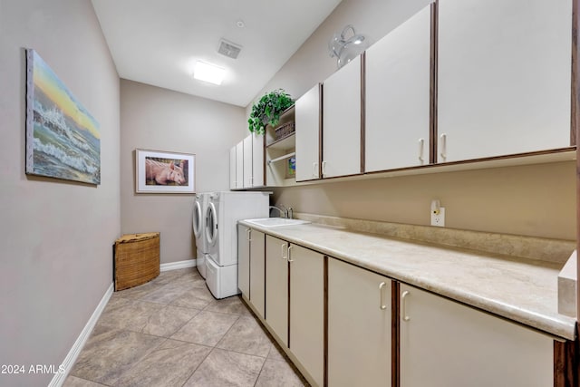 laundry area with cabinets, light tile patterned floors, washer and clothes dryer, and sink