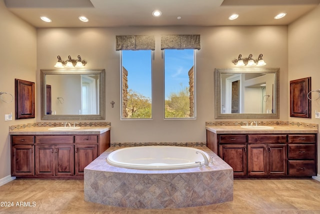 bathroom with vanity and tiled bath