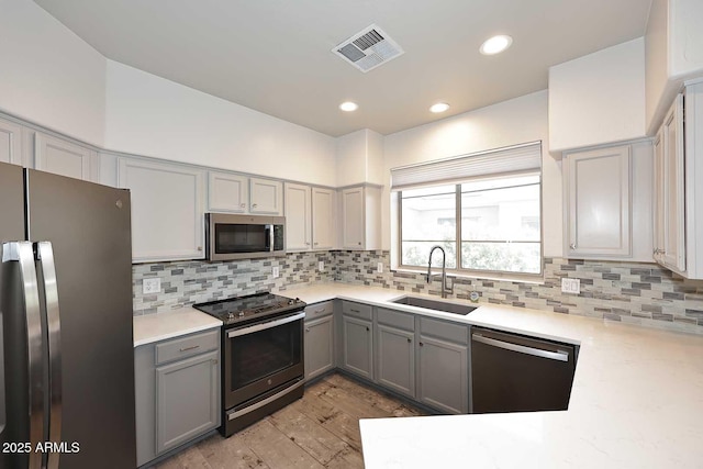 8180 E Shea Blvd Unit 1075, Scottsdale, AZ 85260 - kitchen with appliances with stainless steel finishes, a sink, gray cabinetry, backsplash, and recessed lighting