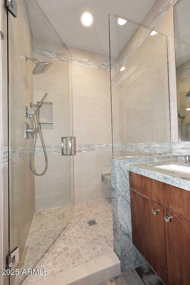 8180 E Shea Blvd Unit 1075, Scottsdale, AZ 85260 - bathroom featuring a shower stall, vanity, recessed lighting, and tile walls