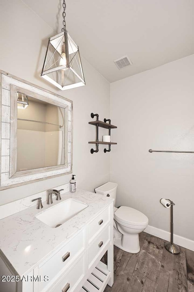 8180 E Shea Blvd Unit 1075, Scottsdale, AZ 85260 - bathroom featuring vanity, wood finished floors, toilet, and baseboards