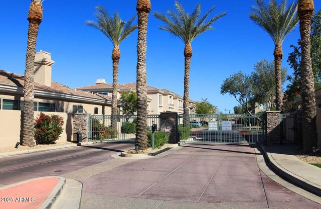 8180 E Shea Blvd Unit 1075, Scottsdale, AZ 85260 - view of concrete road featuring curbs, a gate, and a gated entry