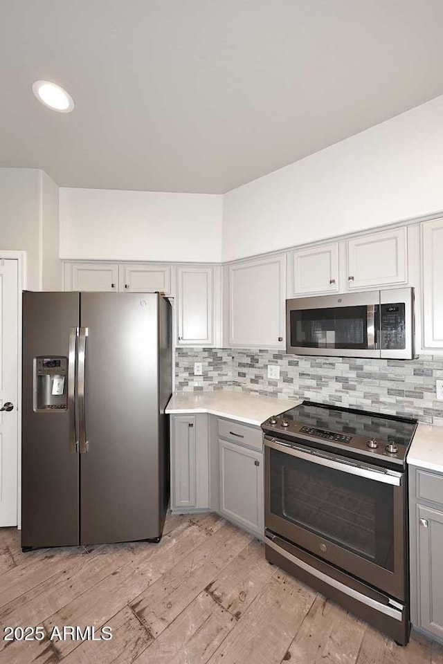 8180 E Shea Blvd Unit 1075, Scottsdale, AZ 85260 - kitchen featuring appliances with stainless steel finishes, gray cabinetry, tasteful backsplash, light countertops, and light wood finished floors