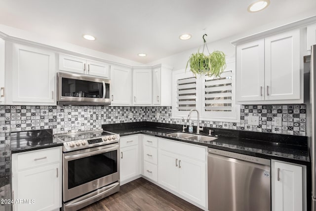 kitchen with sink, dark hardwood / wood-style floors, decorative backsplash, white cabinetry, and stainless steel appliances