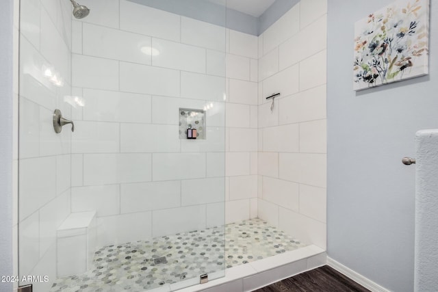 bathroom featuring hardwood / wood-style floors and a tile shower