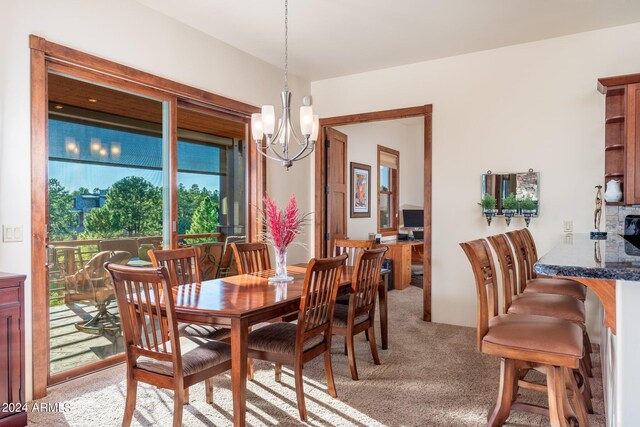 carpeted dining space featuring an inviting chandelier