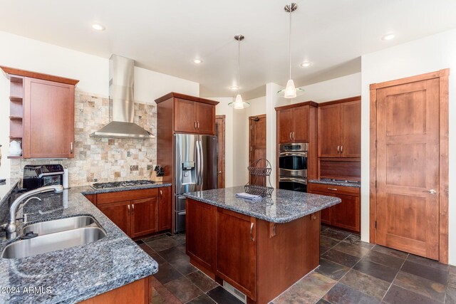 kitchen featuring a kitchen island, stainless steel appliances, sink, decorative backsplash, and wall chimney range hood