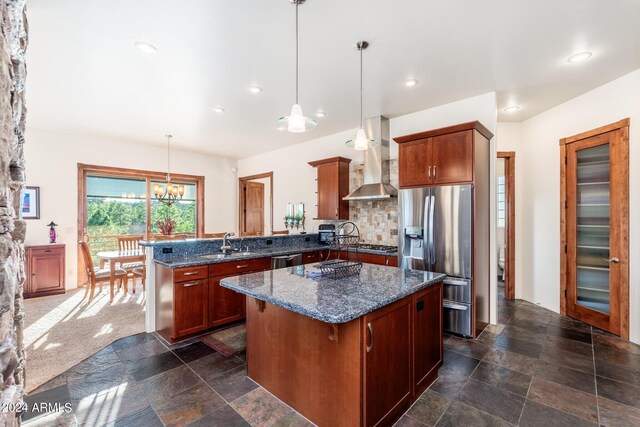 kitchen featuring a center island, appliances with stainless steel finishes, a chandelier, sink, and decorative backsplash