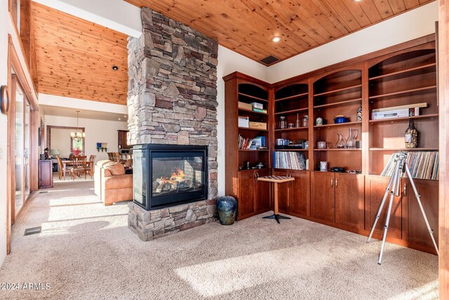 carpeted living room featuring wood ceiling, a notable chandelier, built in shelves, and a fireplace