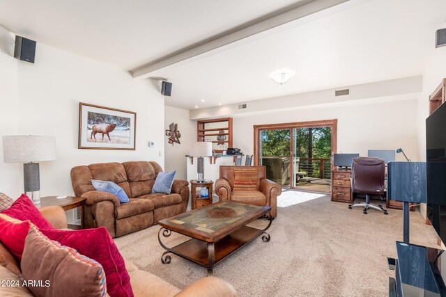 carpeted living room featuring beamed ceiling