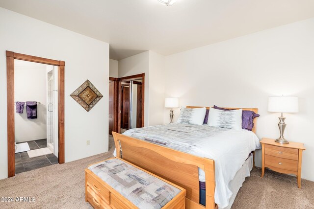 bedroom with dark carpet, a closet, and connected bathroom