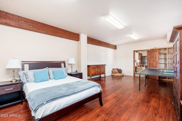 bedroom with dark wood-type flooring and beamed ceiling