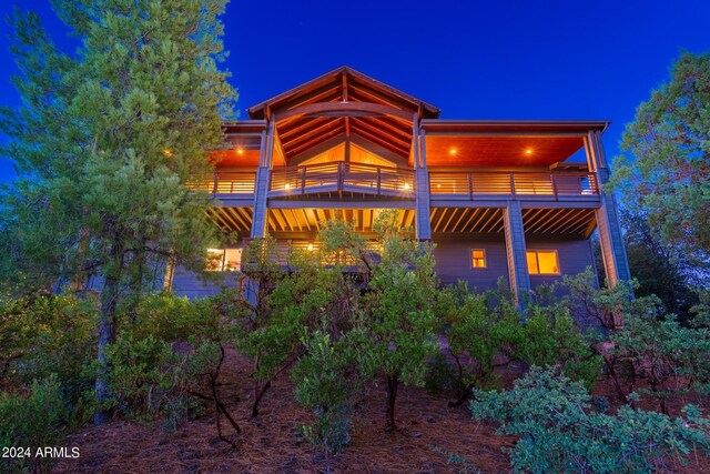 back house at night featuring a balcony