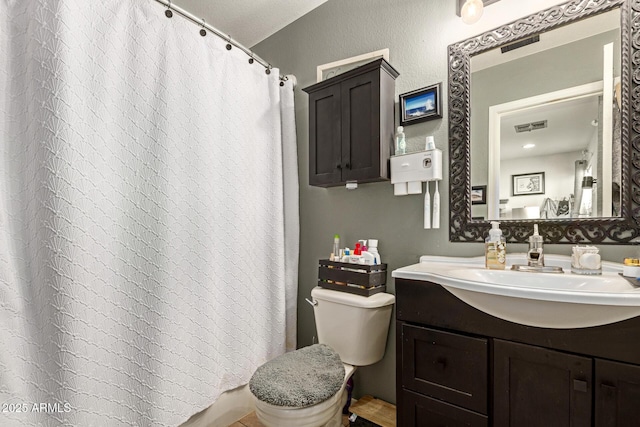 bathroom with toilet, a shower with curtain, visible vents, and vanity