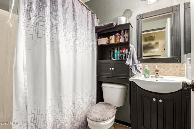 full bathroom with a textured wall, tasteful backsplash, vanity, and toilet