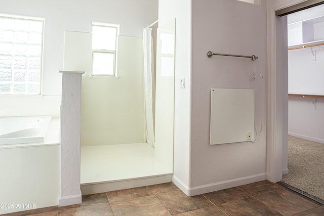 bathroom featuring a spacious closet, curtained shower, and baseboards