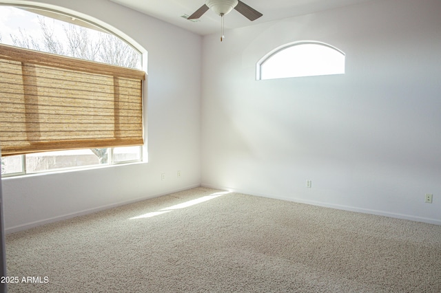 spare room with carpet, ceiling fan, and baseboards