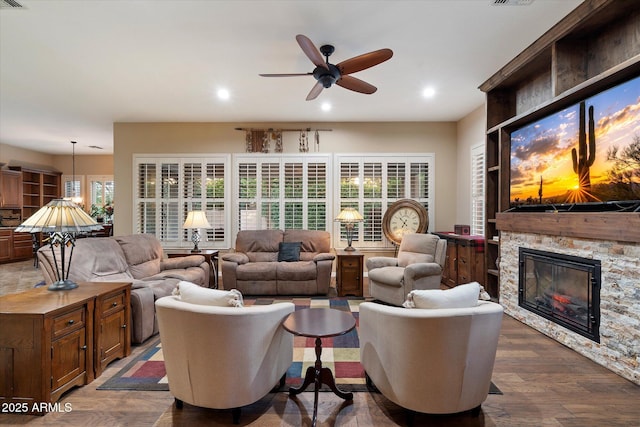 3350 S Holguin Way, Chandler, AZ 85248 - living room with a ceiling fan, a stone fireplace, dark wood-type flooring, and recessed lighting