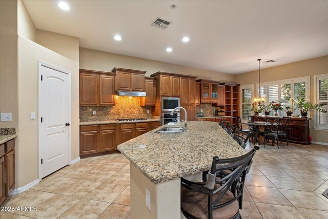 3350 S Holguin Way, Chandler, AZ 85248 - kitchen featuring stainless steel appliances, brown cabinets, a sink, tasteful backsplash, and recessed lighting