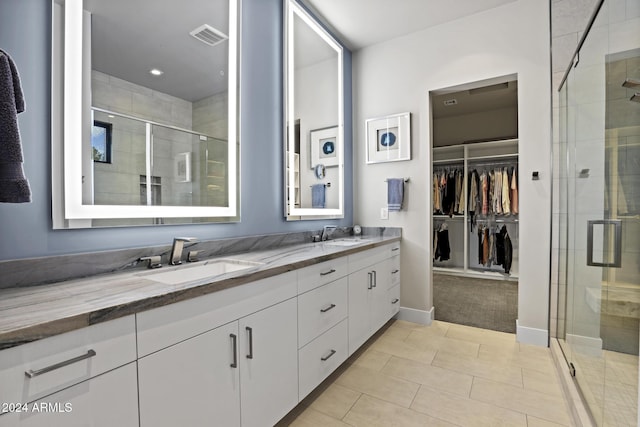 bathroom featuring a shower with door, vanity, and tile patterned flooring