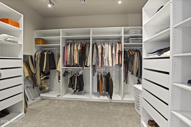 walk in closet featuring light colored carpet